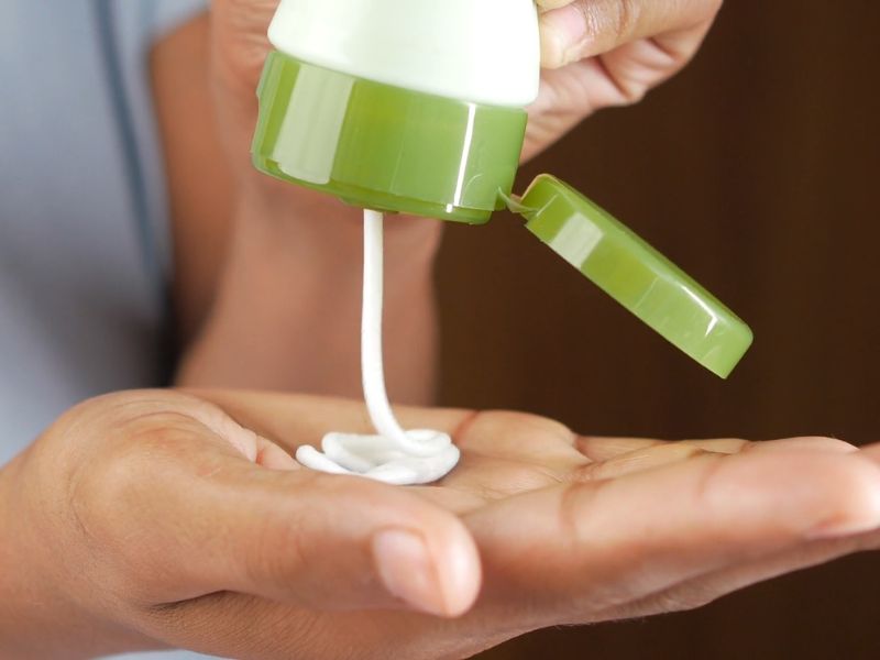 devojka nanosi kremu za telo na ruku