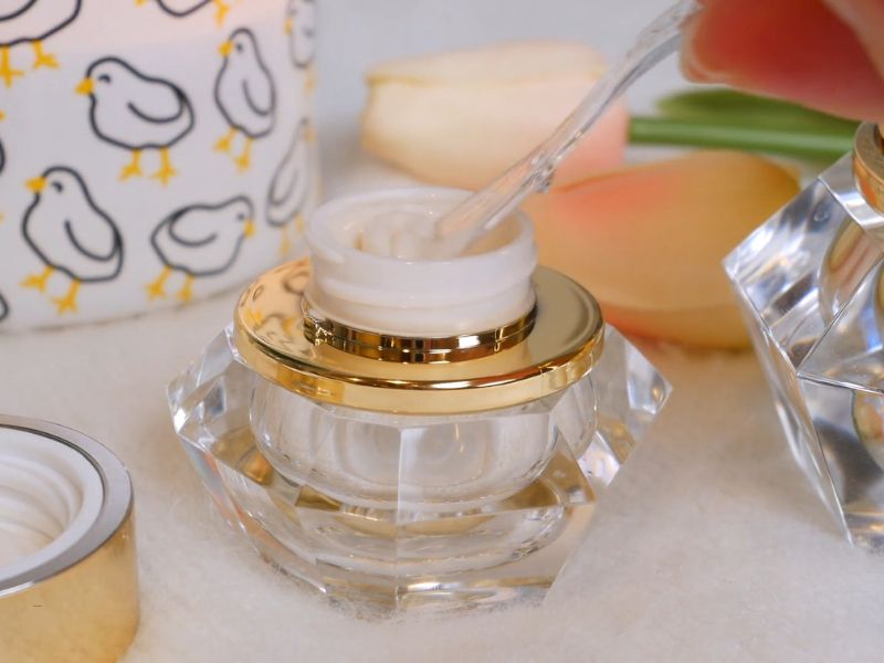 osoba vadi kremu za lice sa špatulicom