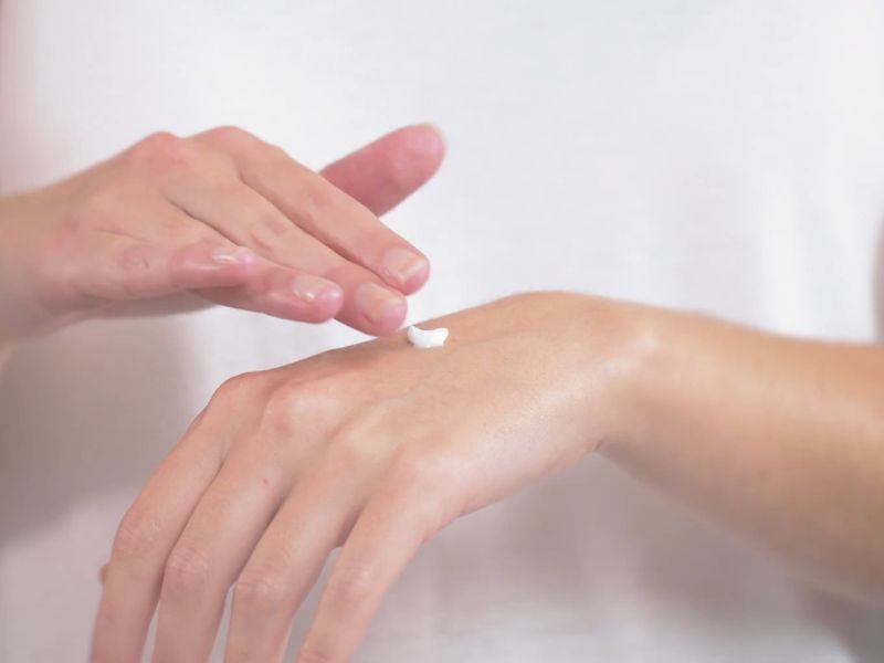 devojka maže losion na kožu